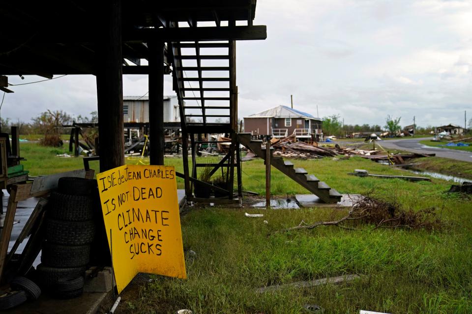 Storm clouds from Tropical Storm Nicholas are seen on Sept. 14, 2021, behind homes of the vanishing Native American community of Isle de Jean Charles, Louisiana, which was devastated by Hurricane Ida. (AP Photo/Gerald Herbert)