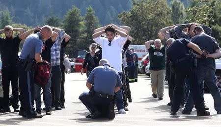 Police officers inspect bags as students and staff are evacuated from campus following a shooting incident at Umpqua Community College in Roseburg, Oregon October 1, 2015. REUTERS/Michael Sullivan/The News-Review