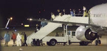 Passengers evacuated from the Grand Princess cruise ship get off a charter flight from California's Oakland International Airport after it arrived at Kelly Field, an enclave of San Antonio, Texas, Tuesday, March 10, 2020. It was the first of two planeloads of ship passengers to make the deliveries Tuesday night. The U.S. Centers for Disease Control and Prevention said 380 Grand Princess passengers are expected to be quarantined at the adjoining Joint Base San Antonio-Lackland. (Bob Owen/The San Antonio Express-News via AP)