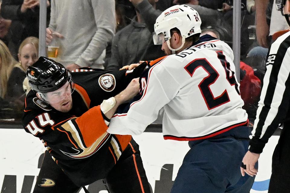 Anaheim Ducks left wing Ross Johnston (44) fights with Columbus Blue Jackets right wing Mathieu Olivier (24) during the second period of an NHL hockey game in Anaheim, Calif., Wednesday, Feb. 21, 2024. (AP Photo/Alex Gallardo)