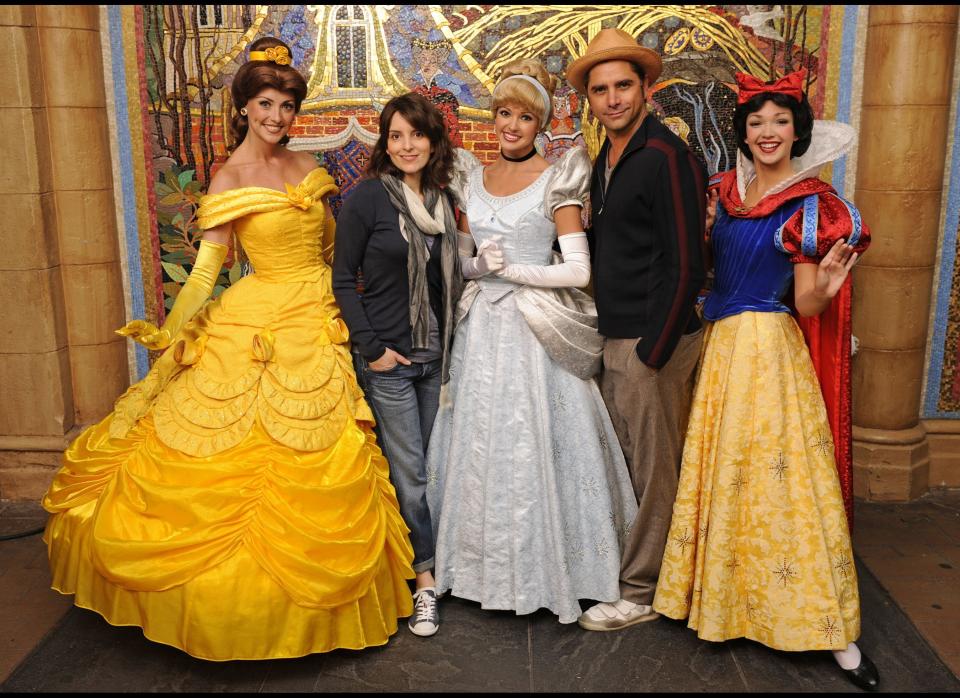 Actors dressed as princesses Belle (L), Cinderella and Snow White pose with '30 Rock' actress and executive producer Tina Fey and 'ER' actor John Stamos inside Cinderella Castle at Magic Kingdom on March 23 in Lake Buena Vista, Florida.      (Photo by Kent Phillips/Walt Disney World Via Getty Images)