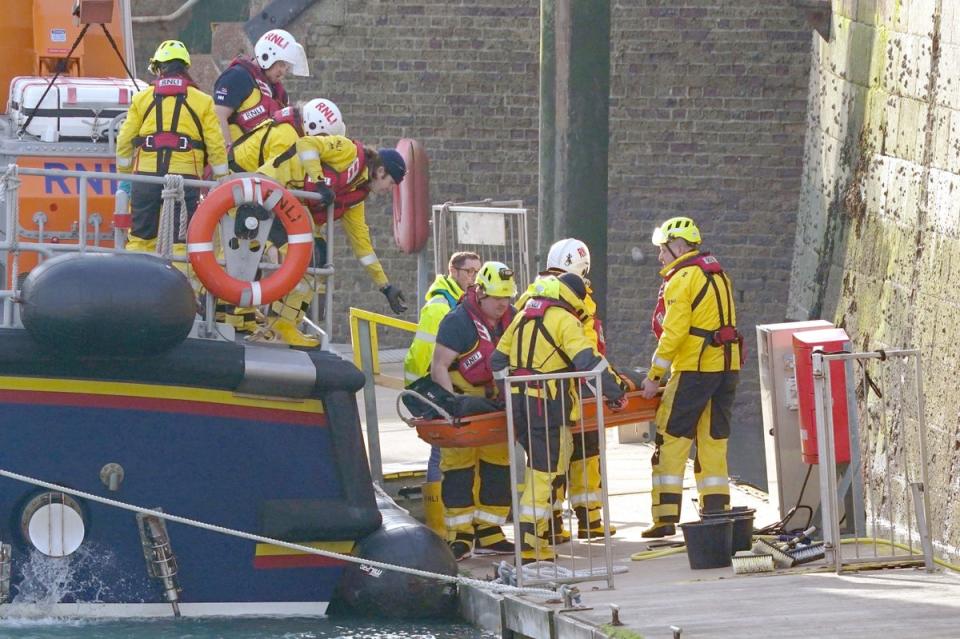 14 December 2022: Members of the RNLI remove a stretcher and body bag from the Dover lifeboat after it returned to the Port of Dover following a large search and rescue operation launched in the Channel off the coast of Dungeness, in Kent, during an incident involving a small boat likely to have been carrying migrants. Three people have died following the incident and 43 people have been rescued, a Government source said (PA)