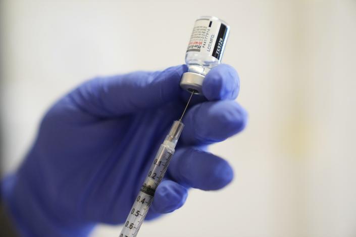 A Pfizer COVID-19 vaccine dose is drawn from a vial during a clinic at Promise Arizona's office in Phoenix on Jan. 26, 2022.