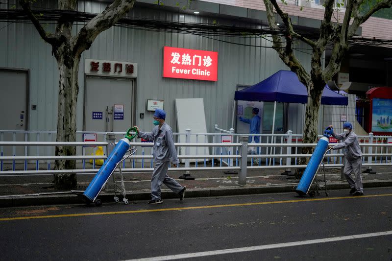 FILE PHOTO: FILE PHOTO: Workers deliver oxygen cylinders outside a hospital in Shanghai