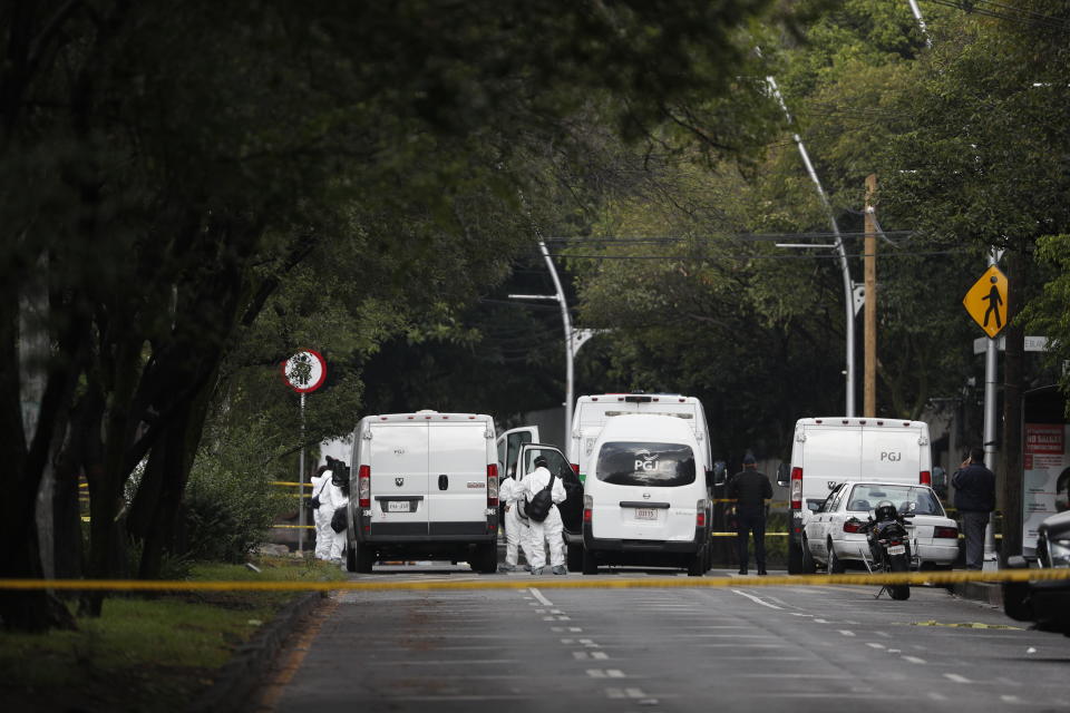 Forensic investigators and police work the scene where security secretary, Omar García Harfuch, was attacked by gunmen in the early morning hours in Mexico City, Friday, June 26, 2020. Heavily armed gunmen attacked and wounded Mexico City’s police chief in a brazen operation that left an unspecified number of dead, Mayor Claudia Sheinbaum said Friday. (AP Photo/Rebecca Blackwell)