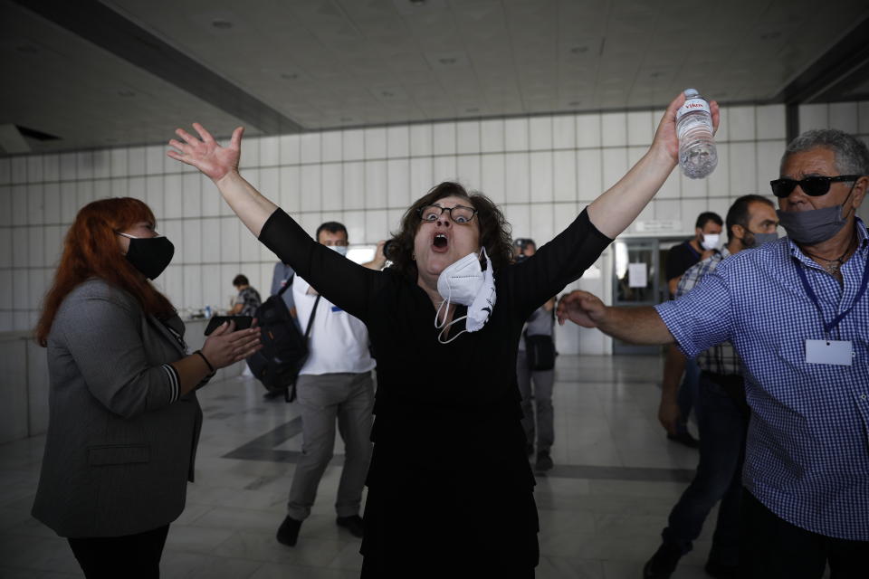 Magda Fyssa, the mother of late Greek rap singer Pavlos Fyssas, who was stabbed and killed by a supporter of the extreme right Golden Dawn party in 2013 triggering a crackdown on the party, celebrates after the announcement of a court decision in Athens, Wednesday, Oct. 7, 2020. The court ruled that the far-right Golden Dawn party was operating as a criminal organization, delivering a landmark guilty verdict in a marathon five-year trial.The court ruled seven of the party's former lawmakers, including party leader Nikos Michaloliakos, were guilty of leading a criminal organization, while the others were guilty of participating in a criminal organization. (AP Photo/Petros Giannakouris)