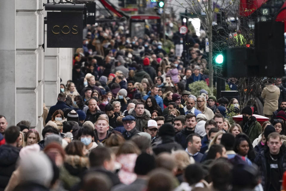 People, some wearing face masks, walk in Regent Street, in London, Sunday, Nov. 28, 2021. Britain's Prime Minister Boris Johnson said it was necessary to take "targeted and precautionary measures" after two people tested positive for the new variant in England. He also said mask-wearing in shops and on public transport will be required. (AP Photo/Alberto Pezzali)
