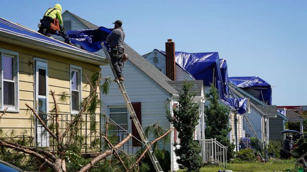 PHOTO: People work on a home's damaged roof the day after multiple homes and businesses were damaged after a tornado, caused by Tropical Rainstorm Ida, swept through Annapolis, Md., Sept. 2, 2021. (Jack Gruber/USA Today Network, FILE)