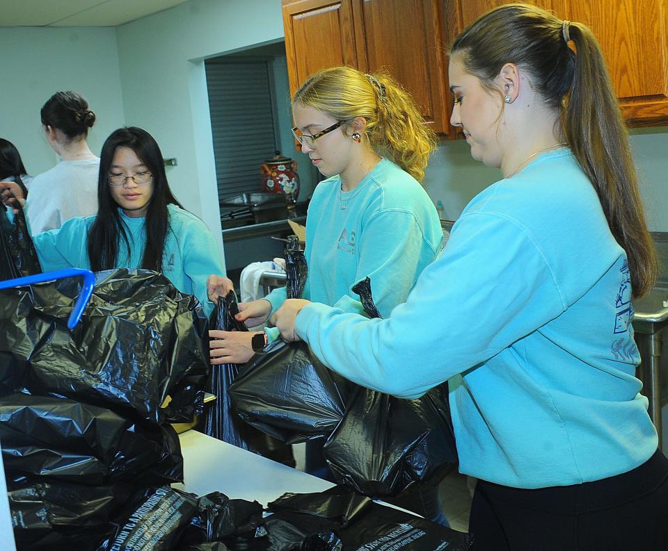 University of Mount Union students, from left, Chessie Misia, Allie Cox and Nia Gribbons prepare takeout containers Sunday, Nov. 13, 2022, during the annual Community Thanksgiving Luncheon at the Alliance Salvation Army.
