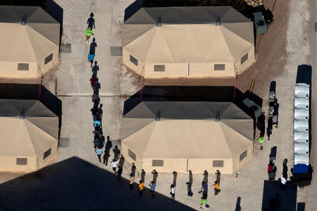 FILE PHOTO: Immigrant children are led by staff in single file between tents at a detention facility next to the Mexican border in Tornillo, Texas, U.S., June 18, 2018. REUTERS/Mike Blake/File Photo