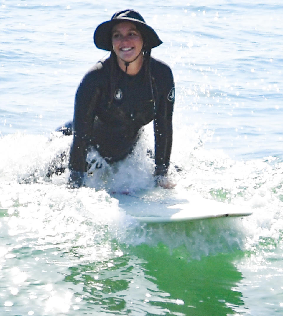 <p>Leighton Meester catches a wave during a surf session with husband Adam Brody on Monday in Malibu. </p>