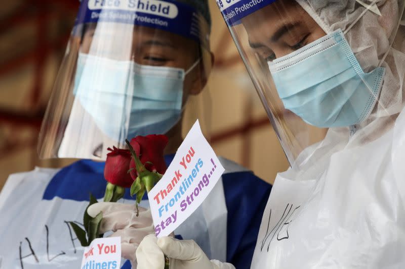 Medical workers hold roses given by the public at a coronavirus disease (COVID-19) testing centre in Petaling Jaya