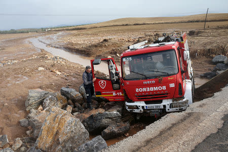 A firefighter checks a destroyed firefighter truck on a road where a firefighter died as heavy rain and flash floods hit Campillos, southern Spain, October 21, 2018. REUTERS/Jon Nazca