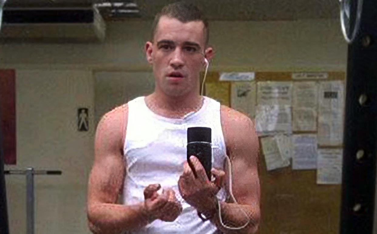 McSweeney takes a selfie in a mirror, wearing a sleeveless vest