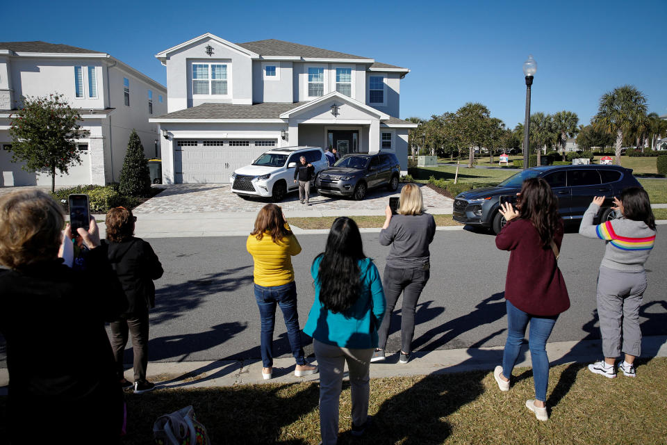 Supporters of former Brazilian President Jair Bolsonaro stand in front of the house he is staying as cardiologist Ricardo Pexoito Camarinha leaves, in Kissimmee, Fla., on Jan. 11, 2023.<span class="copyright">Marco Bello—Reuters</span>