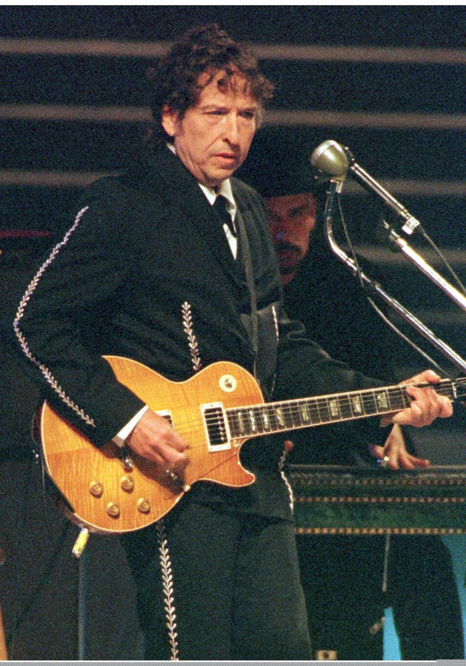 American singer Bob Dylan performs in front of some 350,000 people during a rock concert attended by Pope John Paul II at Bologna late 27 September. The pope cited one of Dylan 's best known hit songs " Blowin ' in the Wind" when he told the crowd that Jesus held the answers to their queries about life. 