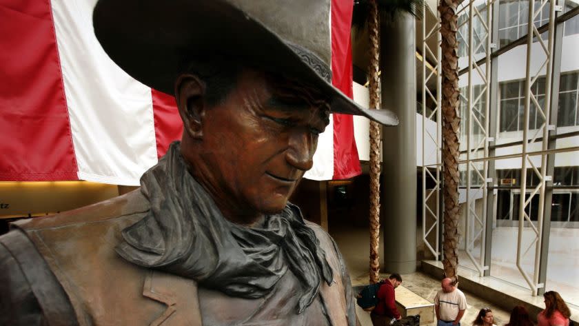 Boster, Mark –– – 123034.ME.0417.JohnWayne.MJB––(Newport Beach)–Silver screen legend John Wayne is immortalized in a bronze statue on the baggage level at the Orange County Airport bearing his name. However, Newport Beach wants to fete Wayne on his 100th birthday, but can't throw a party at his old house in Newport because the structure was torn down by the new residencts. The Duke's final resting place, the statue at the airport and a bar in Newport appear to be the last honors in a town that he called home.April 16, 2007