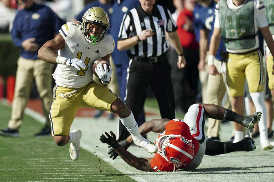 Georgia Tech running back Dontae Smith (4) tries to stay in bounds as Georgia linebacker Trezmen Marshall (15) defends during the first half of an NCAA college football game Saturday, Nov. 26, 2022 in Athens, Ga. (AP Photo/John Bazemore)