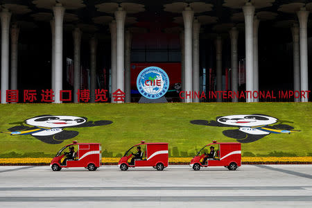 Firemen drive electric firetrucks in front of the National Exhibition and Convention Center, the venue for the upcoming China International Import Expo (CIIE), in Shanghai, China November 3, 2018. REUTERS/Aly Song