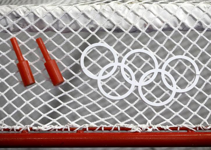 The Olympic rings are displayed on the net of an ice hockey goal as pegs for the goal posts lay on top of the net ahead of the 2014 Winter Olympics, Thursday, Feb. 6, 2014, in Sochi, Russia. (AP Photo/Julio Cortez)