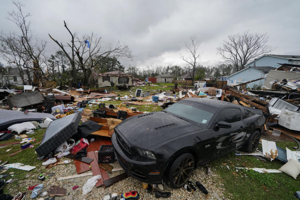 A car sits amid the destruction in the wake of a tornado that tore through Killona, La.