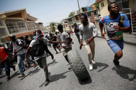 Demonstrators roll a tire along a street during a protest in Port-au-Prince, Haiti, July 14, 2018. REUTERS/Andres Martinez Casares