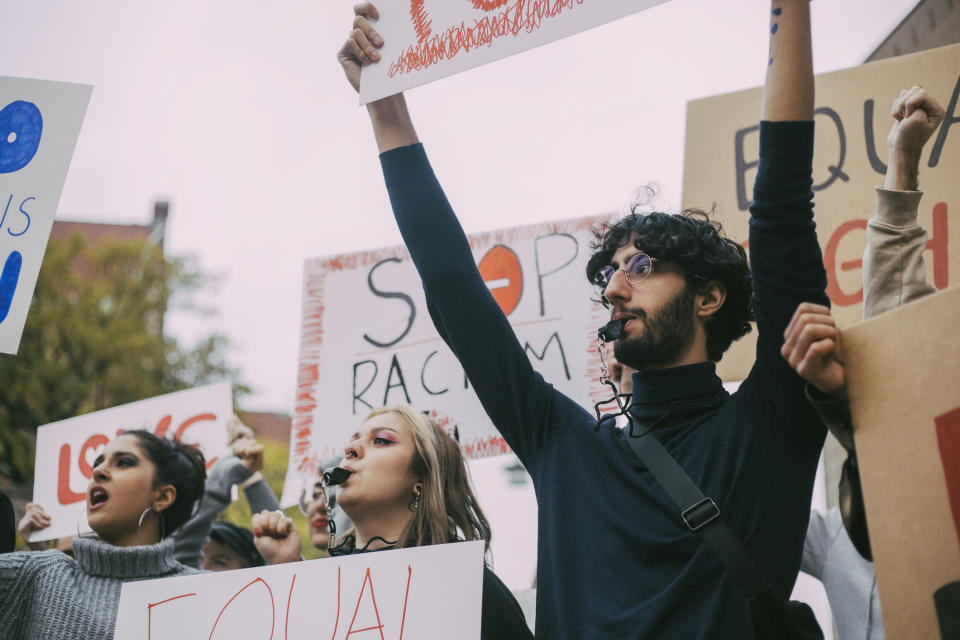 A group of young people hold signs during a protest