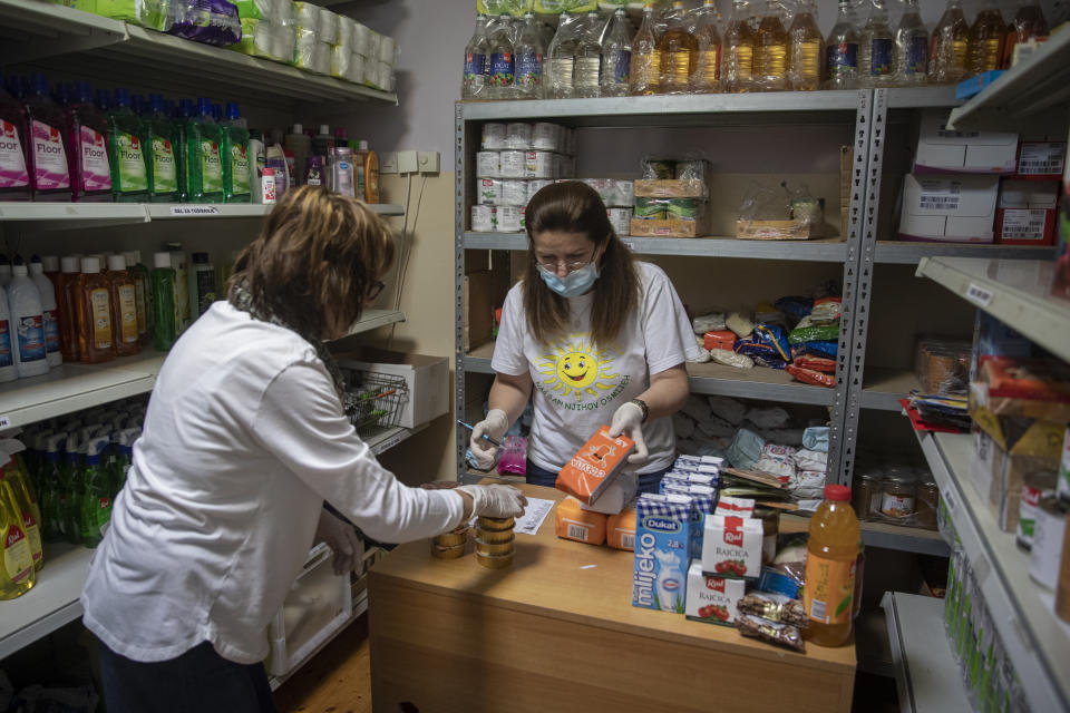 Volunteers prepare packages of aid for people in need for help in Pula, Croatia, Tuesday, May 26, 2020. "Our Dream Their Smile" group has helped people in the tourism-dependent area in the Adriatic survive as the outbreak closed down borders, shutting down hotels, restaurants and other businesses that normally thrive in virus-free times. (AP Photo/Darko Bandic)