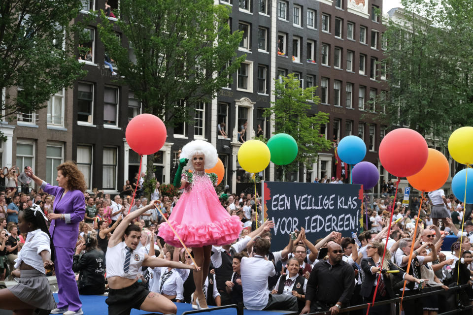 People take part in the Amsterdam Pride Parade, in Amsterdam, Netherlands, Saturday, Aug. 3, 2019. Tens of thousands of spectators are lining one of Amsterdam’s main canals to watch a flotilla of decorated boats make their way through the historic waterway as part of the Dutch capital’s nine-day pride festival. Sign reads, 'A safer class for everyone.' (AP Photo/Michael Corder)