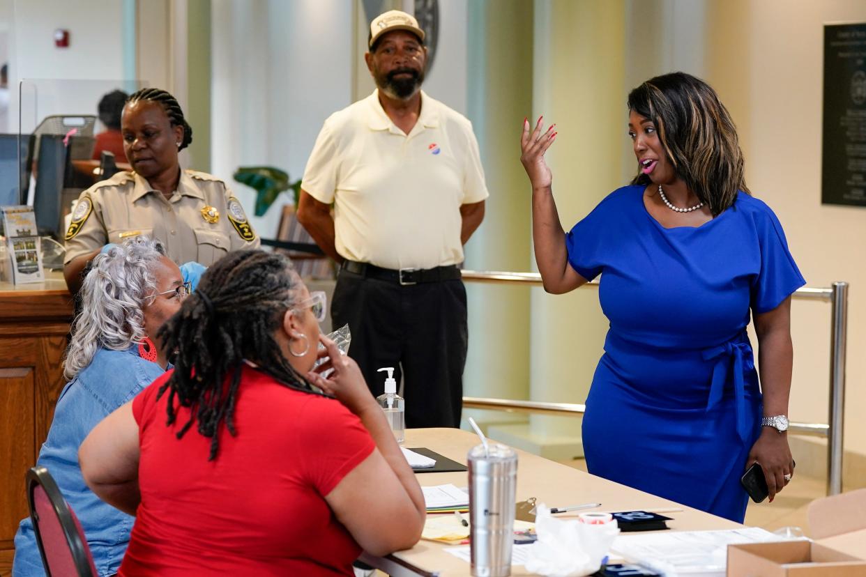 Former Virginia State Delegate Lashrecse Aird, right, talks with poll workers as she visits a polling precinct Tuesday, June 20, 2023, in Surry, Va. Aird defeated Sen. Joe Morrissey in a Democratic primary for a newly redrawn Senate district.