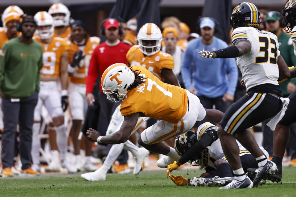 Tennessee quarterback Joe Milton III (7) dives for yardage as he's hit by Missouri defensive back Jalani Williams (4) during the second half of an NCAA college football game Saturday, Nov. 12, 2022, in Knoxville, Tenn. Tennessee won 66-24. (AP Photo/Wade Payne)