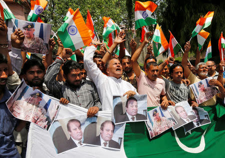 People shout slogans as they hold portraits of Pakistan's Prime Minister Nawaz Sharif and Pakistan's army chief Lieutenant General Qamar Javed Bajwa during a protest organized by Shiv Sena, a Hindu hardline group, in Jammu, May 2, 2017, against the killing of two Indian soldiers who were patrolling the de facto border in the disputed Kashmir region on Monday. REUTERS/Mukesh Gupta