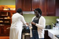 Ebele Azikiwe, 12, right, cooks with her mother, Rume Joy Azikiwe-Oyeyemi, at home in Cherry Hill, N.J., Wednesday, March 24, 2021. Ebele testified in October at state Assembly hearing, lending her support to legislation requiring New Jersey's school districts to add diversity to curriculums. Democratic Gov. Phil Murphy signed the bill into law. (AP Photo/Matt Rourke)