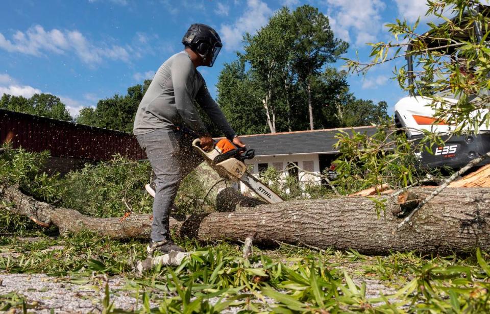 William Guerra works to remove a downed tree near Guess Road on Wednesday, August 16, 2023, following strong storms in Durham, N.C. on Tuesday evening. Kaitlin McKeown/kmckeown@newsobserver.com