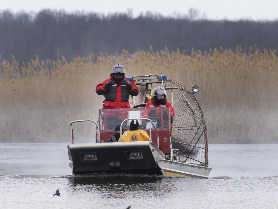 Searchers look for victims in Akwesasne, Quebec, Friday, March 31, 2023. Authorities in the Mohawk Territory of Akwesasne said Friday one child is missing after the bodies of six migrants of Indian and Romanian descent were pulled from a river that straddles the Canada-U.S. border. (Ryan Remiorz/The Canadian Press via AP)