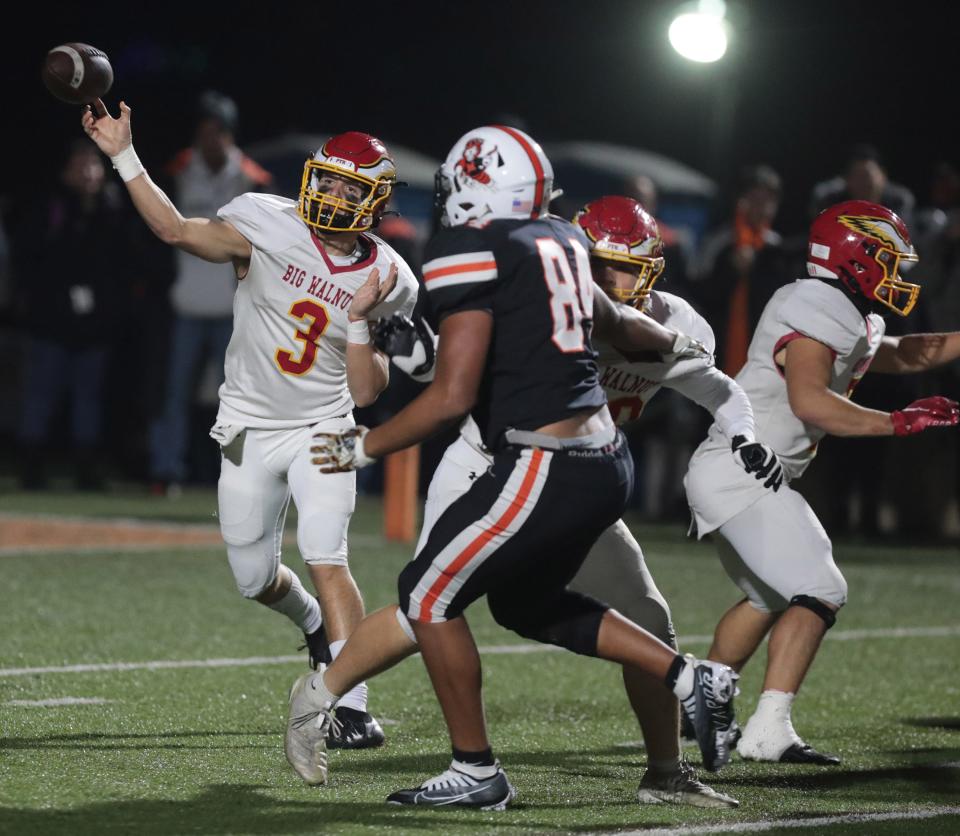 Big Walnut quarterback Jake Nier throws a second half pass with pressure from Massillon's Chase Bond at Mansfield's Arlin Field in this Div. II playoff game Friday, November 11, 2022.