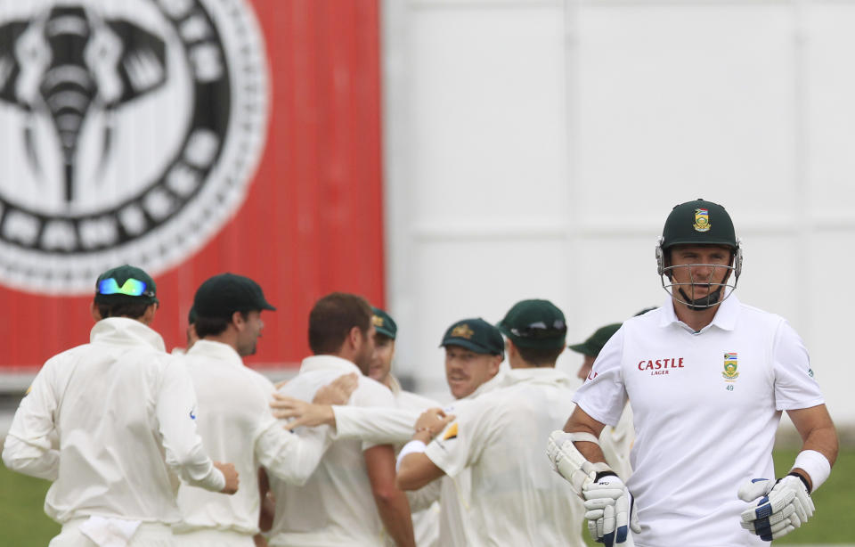 South Africa's captain Graeme Smith, right, walks back to the players pavilion after dismissed by Australia's bowler Ryan Harris, for 9 runs on the first day of their 2nd cricket test match at St George's Park in Port Elizabeth, South Africa, Thursday, Feb. 20, 2014. (AP Photo/ Themba Hadebe)