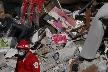 A photo of a child is seen among the ruins of a 17-storey apartment building that collapsed after an earthquake hit Tainan, southern Taiwan February 7, 2016. REUTERS/Tyrone Siu