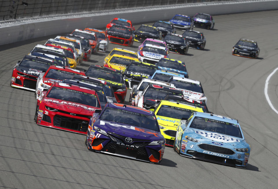 Denny Hamlin (11) leads the field into Turn 1 during a NASCAR Cup Series auto race at Michigan International Speedway in Brooklyn, Mich., Sunday, Aug. 12, 2018. (AP Photo/Paul Sancya)