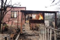 A fire burns a house in Rovies village on the island of Evia, about 160 kilometers (100 miles) north of Athens, Greece, Wednesday, Aug. 4, 2021. Greece evacuated people in boats from an island beach Wednesday amid heavy smoke from a nearby wildfire and fire crews fought elsewhere to keep flames away from the birthplace of the ancient Olympic Games as the country sweltered under a record heat wave. (AP Photo/Thodoris Nikolaou)