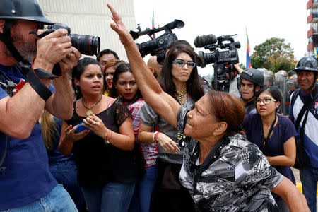 A supporter of Venezuela's President Nicolas Maduro tries to take the camera of a photographer away, during clashes with opposition supporters outside the Supreme Court of Justice (TSJ) in Caracas, Venezuela March 30, 2017. REUTERS/Carlos Garcia Rawlins