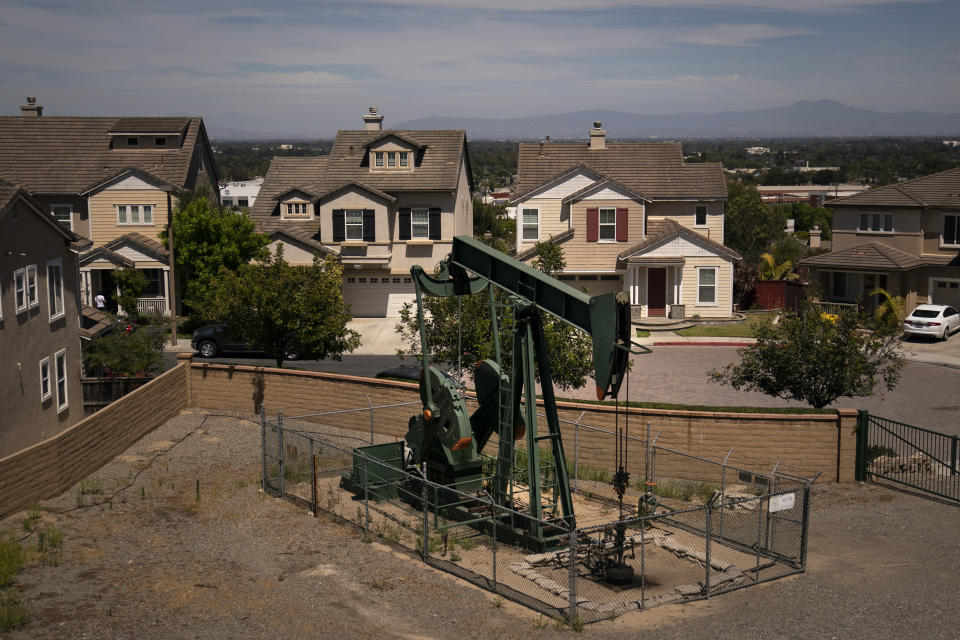 FILE - A pump jack extracts oil at a drilling site next to homes June 9, 2021, in Signal Hill, Calif. Residents in several regions of California allege that they’ve been misled by signature gatherers over the last two months as a campaign, Stop the Energy Shutdown, pushed to gather enough signatures to get a referendum to overturn SB 1137 on the 2024 statewide ballot. SB 1137, a law passed to ban new oil and gas wells within 3,200 feet (975 meters) of schools, homes and hospitals, was signed into law by California Gov. Newsom in September. (AP Photo/Jae C. Hong, File)