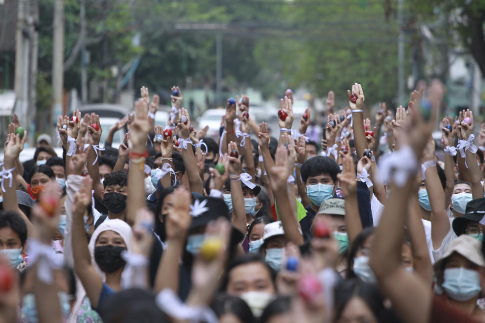 Anti-coup protesters raise decorated Easter eggs along with the three-fingered symbols of resistance during a protest against the military coup on Easter Sunday, April 4, 2021, in Yangon, Myanmar. (AP Photo)