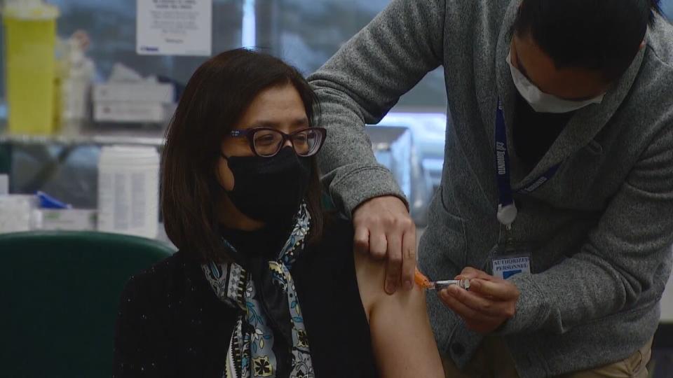 Dr. Eileen de Villa is getting a flu shot in her arm.