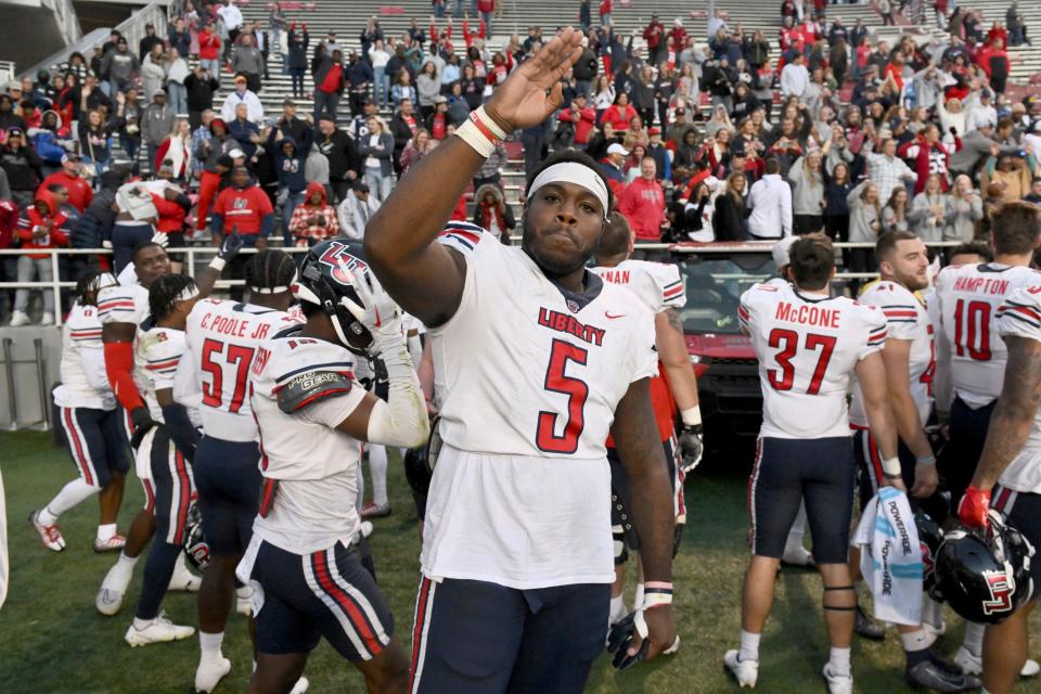 Liberty defensive tackle Dre Butler (5) celebrates with his team after defeating Arkansas in an NCAA college football game Saturday, Nov. 5, 2022, in Fayetteville, Ark. (AP Photo/Michael Woods)