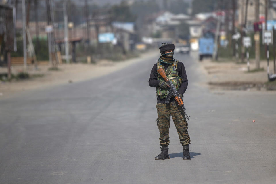 An Indian paramilitary soldier stands guard on a road leading towards the site of a gunfight in Pampore, south of Srinagar, Indian controlled Kashmir, Saturday, Oct. 16, 2021. Indian government forces killed five rebels in last 24-hours in disputed Kashmir on Saturday, officials said, as violence increased in recent weeks. (AP Photo/Dar Yasin)