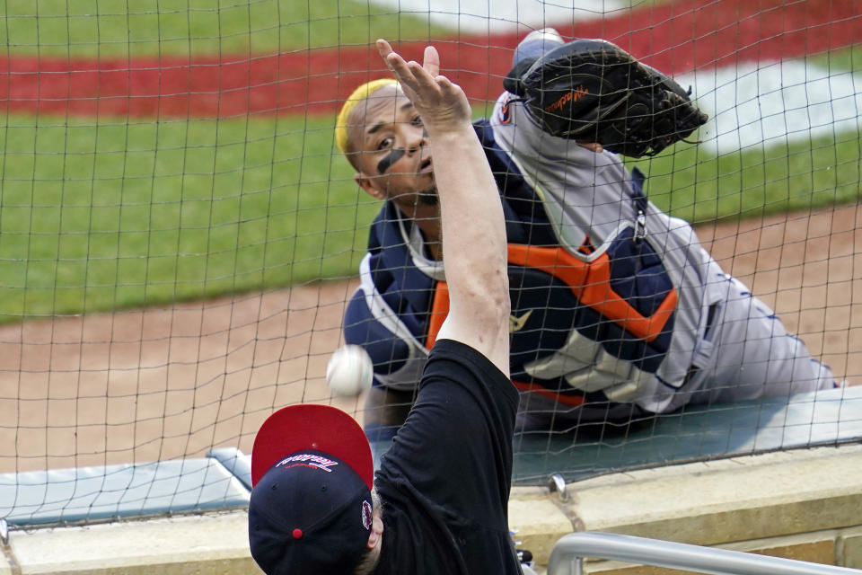 Houston Astros catcher Martin Maldonado, top, makes a try for a foul ball off the bat of Minnesota Twins' Josh Donaldson but it went inside the mesh fencing by a fan in the first inning of a baseball game, Friday, June 11, 2021, in Minneapolis. (AP Photo/Jim Mone)