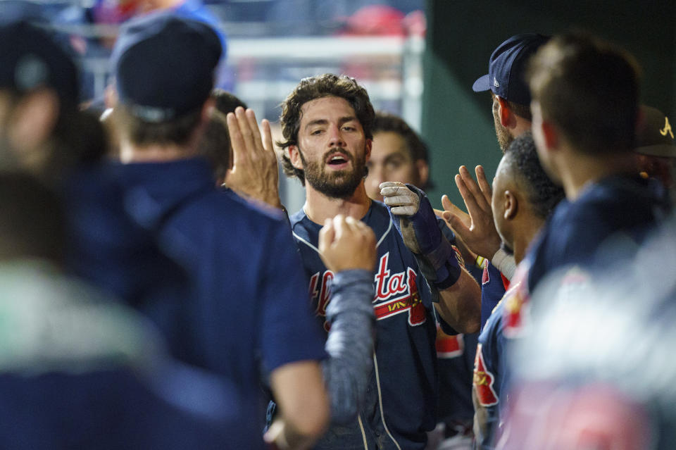 Atlanta Braves' Dansby Swanson, center, is congratulated in the dugout after scoring during the sixth inning of the team' baseball game against the Philadelphia Phillies, Wednesday, June 9, 2021, in Philadelphia. (AP Photo/Chris Szagola)