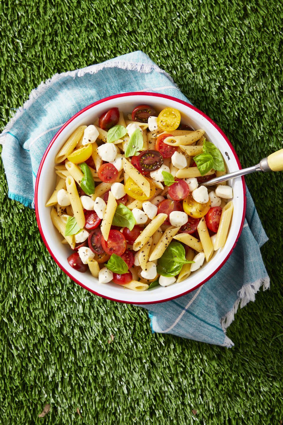 caprese pasta salad in a bowl on the lawn