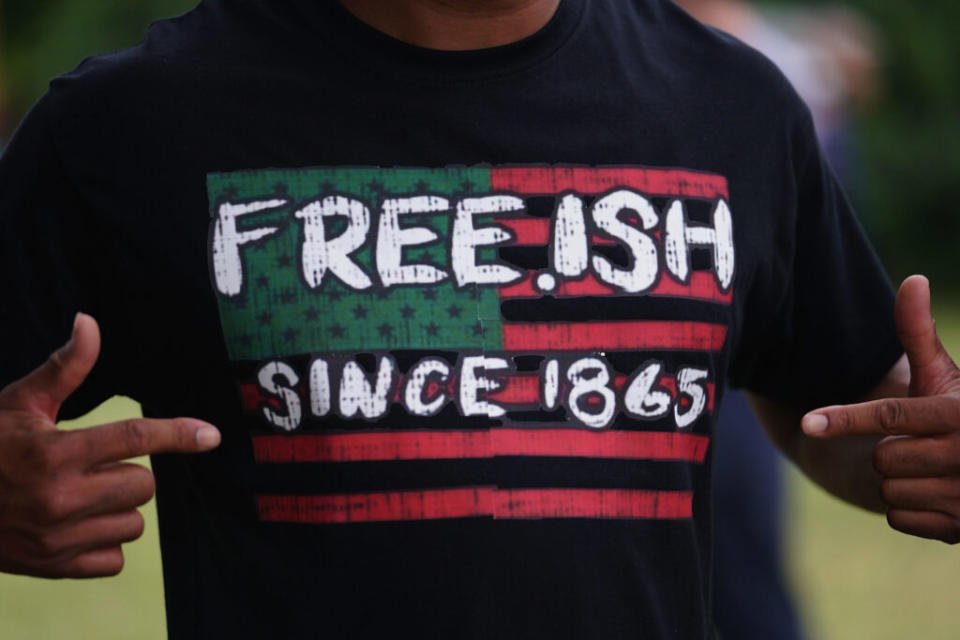 A man shows his Juneteenth shirt which reads "free-ish since 1865"